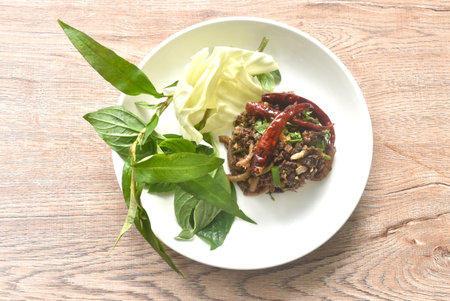 spicy fried chop pork salad Thai northern style with fresh vegetable on plateの写真素材