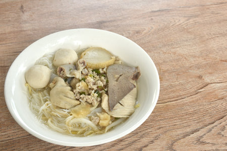 boiled vermicelli thin rice noodles topping pork ball with chop pork in clear soup on bowl