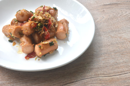 deep fried salty pork sausage with chop garlic and chili pepper arranging on plateの写真素材
