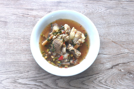 boiled slice braised beef meat with chili in clear tom yum soup on bowl