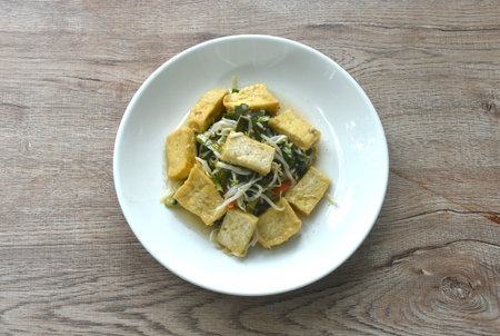fried bean sprout and garliv chive with slice yellow tofu vegetarian food on plate