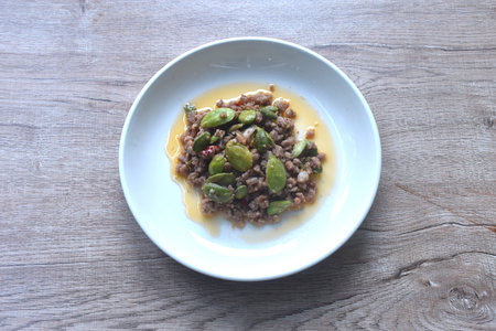spicy fried chop pork with flat bean in shrimp paste curry Thai southern food on plateの写真素材