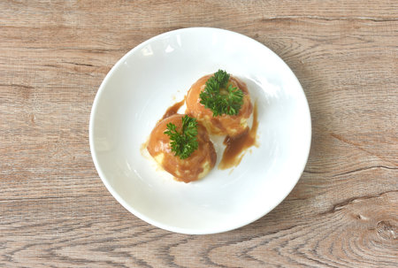 mashed potato dressing gravy sauce topping fresh parsley on plate