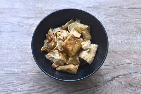 fried slice yellow tofu with celery in soy sauce vegetarian food on bowlの写真素材