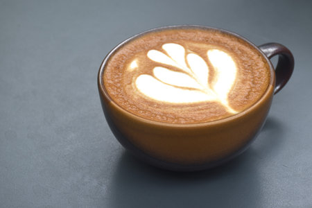 hot cappuccino coffee with latte art in cup on tableの写真素材