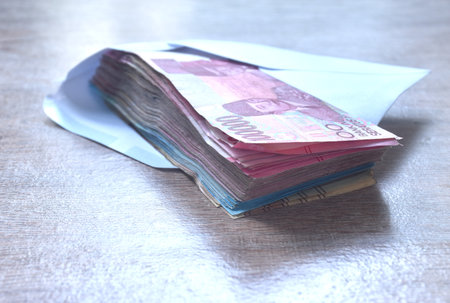 indonesia rupiah banknote in white envelope on wooden tableの写真素材