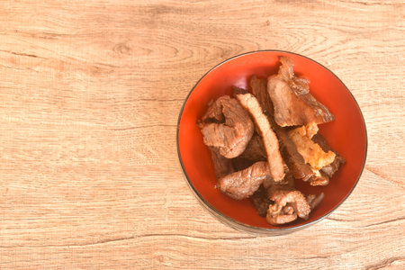fried crispy salty fermenting beef fat meat with pepper on bowlの写真素材
