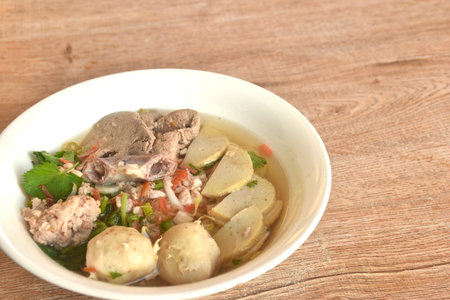 slice Vietnamese sausage and chop pork with meatball in clear soup on bowl