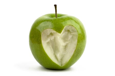 Green apple with a bite with a shape of a heartの写真素材