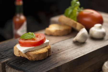 wood table with an italian antipasto, with fresh cheese, tomato and basilの写真素材