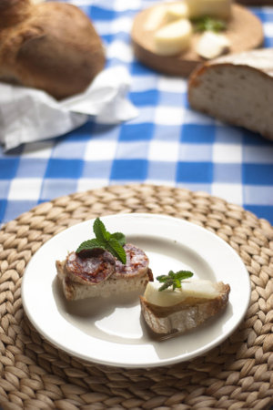 A traditional blue table with a plate with cheese and salami tapasの写真素材