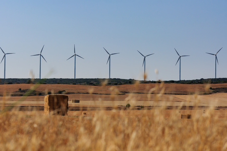 a farm field of the countryside with straw bales,and wind turbines, agriculture landscape,...