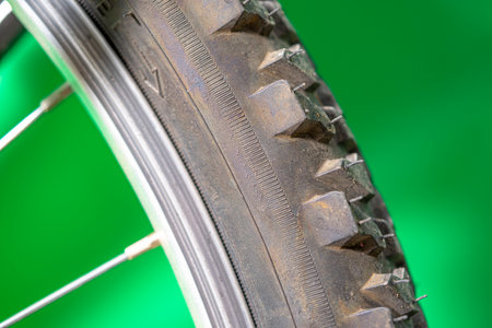 detail of a black bicycle tire with fur on the surface. green background