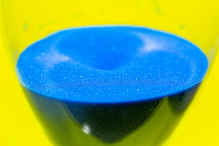 Blue sand hourglass with a yellow background suggesting the colors of the Ukrainian flag and the...