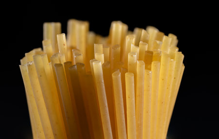 Close up of uncooked Italian pasta on black background. Selective focus.