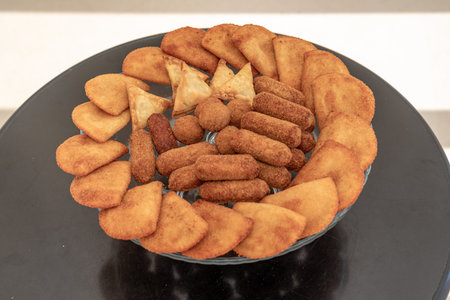 Deep fried chicken nuggets in a glass plate on a black background