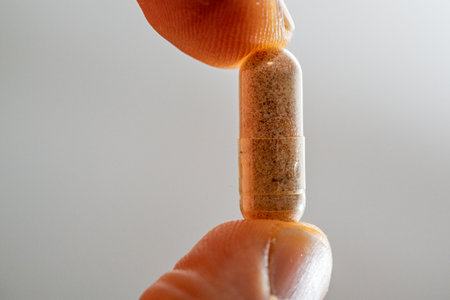 Close-up of a pill in a hand on a white backgroundの写真素材