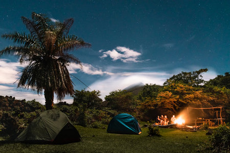 An improvised reunion takes place at the skirts of the active volcano, gathered by a camp fire and surrounded by nature.の写真素材