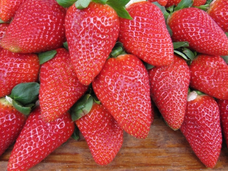 Strawberry harvest stored on wooden table.の写真素材