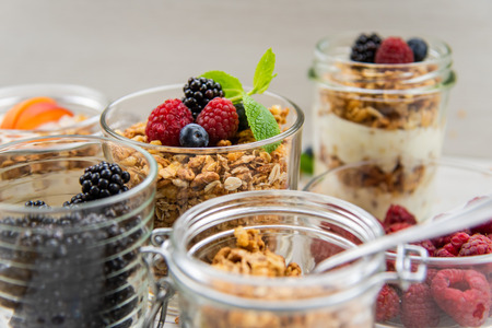 Jars full with granola, yogurt and fresh berries, close-up, selective focusの写真素材