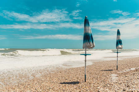 Closed beach umbrellas on a beach on the Adriatic Sea in Italy.の写真素材