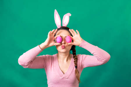 Happy young woman holding a plate with Easter eggs, Happy Easter concept, studio shot.の写真素材