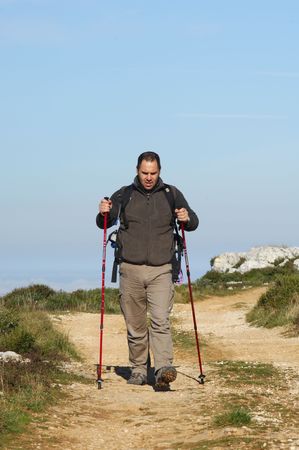 A handsome middle age hispanic latin man in a top of a in mountain hikingの写真素材