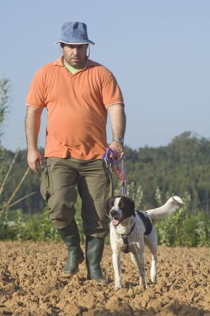 Farmer walking with is dog on the farm の写真素材