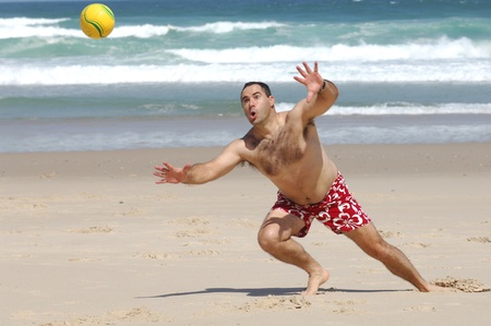A fat man playing with a ball on the beachの写真素材