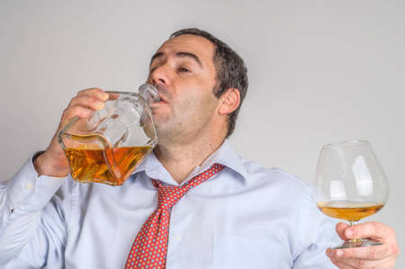 Drunk Businessman drinking whiskyの写真素材