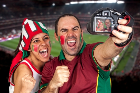 soccer fans with the stadium on the back の写真素材