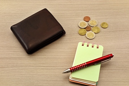 Euro bills, notebook and pen on the table