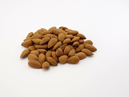 almonds scattered on a white backgroundの写真素材