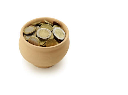 coins in earthen bowl on white backgroundの写真素材