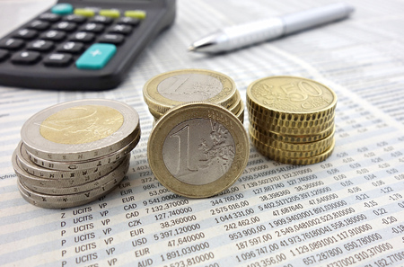 Euro coins on newspaper and pen macroの写真素材