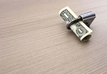 one dollar banknote and padlock on the tableの写真素材