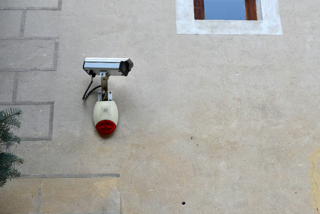 security camera and siren alarm system on the wall of the houseの写真素材