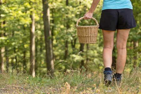 Girl with wicker basket in the woodsの写真素材