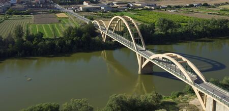 concrete suspension bridge crossing a wide riverの写真素材