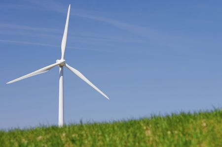 modern windmill looming in a green meadowの写真素材