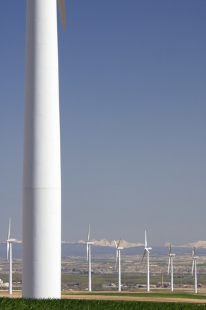 group of aligned windmills with snowy mountainsの写真素材