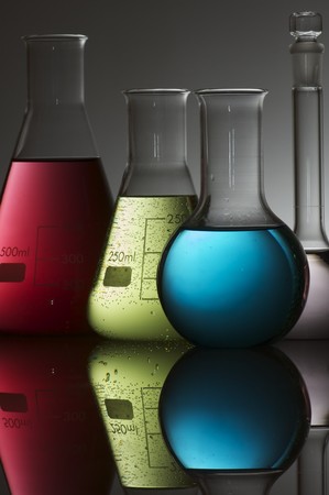 forefront of a group of flasks with brightly colored liquidの写真素材