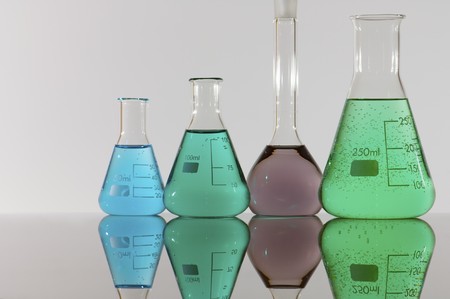 four chemical laboratory flasks with colored liquidの写真素材