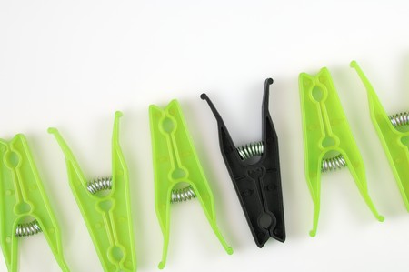 Green and black cloth pegs isolated in a white backgroundの写真素材