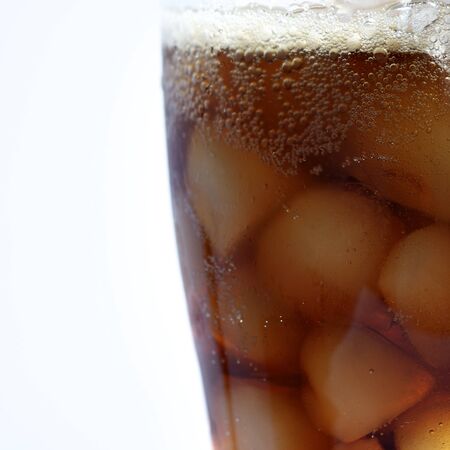 closeup of a glass filled with ice and cola