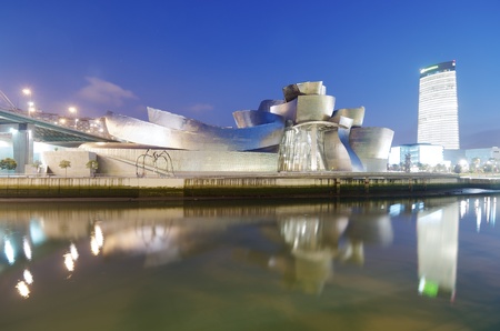 Bilbao, Biscay, Basque Country, Spain, July 30, 2011: night view of the  Guggenheim Museum and Iberdrola Tower at sunset. Guggenheim Museum is dedicated  exhibition of modern art and was  designed by architect Frank Gehry.のeditorial素材