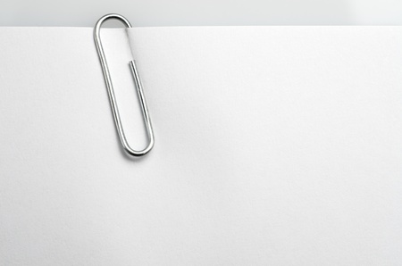 closeup of a metal clip  holding a white paperの写真素材