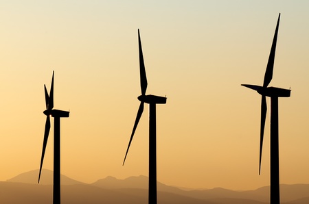 aligned windmills for renowable electric production at sunsetの写真素材