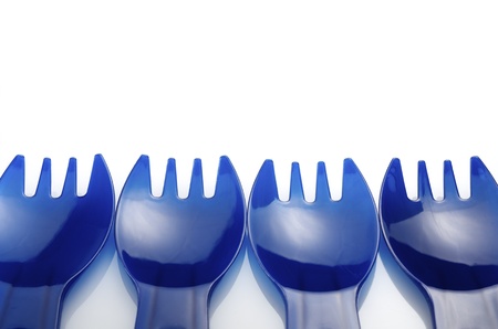 four  disposable plastic forks on a white background