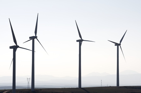 aligned windmills for renowable electric production with white skyの写真素材